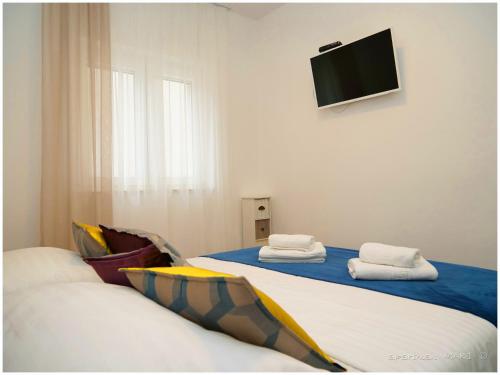 a room with two beds and a flat screen tv at MARI in Dolac
