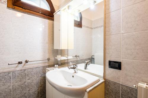 La salle de bains est pourvue d'un lavabo et d'un miroir. dans l'établissement Homiday - Tuscany House - Parcheggio e Giardino Privato, à Pise