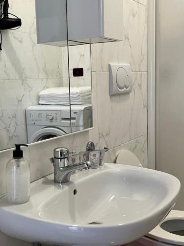 een witte wastafel in een badkamer met een spiegel bij Appartamento estivo seconda fila dal mare in Grottammare
