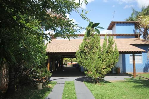 una casa con una puerta y un patio con árboles en Chácara Bonfante, en Olímpia