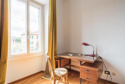 a desk and a chair in a room with a window at Stylish Pigneto Apartment in Rome