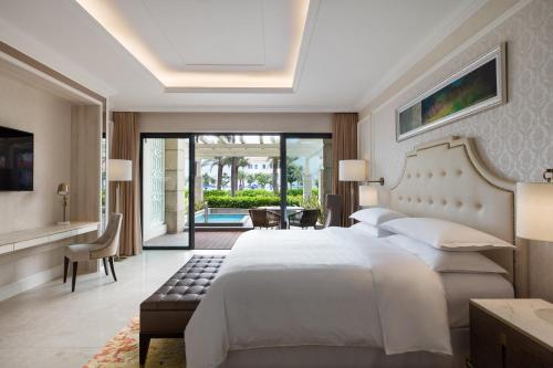 sypialnia z dużym białym łóżkiem i patio w obiekcie Sheraton Grand Danang Resort & Convention Center w mieście Da Nang