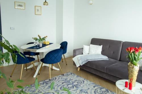 a living room with a couch and a table and chairs at Nowy Apartment przy Placu Szembeka in Warsaw
