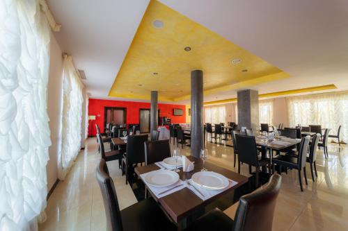 a dining room with tables and chairs and red walls at Hotel Aqua Thermal Spa in Baile Felix