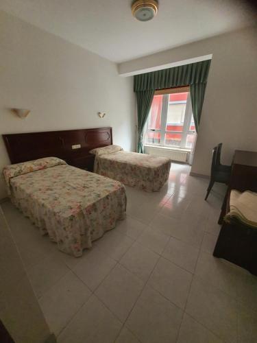 pokój hotelowy z 2 łóżkami i oknem w obiekcie Flor de Loto w mieście Ordes