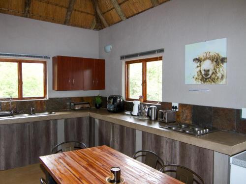 a kitchen with a table and a sheep on the wall at Ingwe Bush Lodge in Hoedspruit