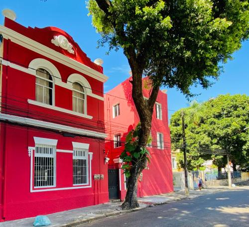 un edificio rojo con un árbol delante de él en Reef Hostel & Pousada en Recife