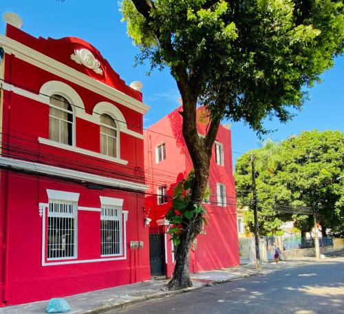 un edificio rojo con un árbol delante de él en Reef Hostel & Pousada, en Recife