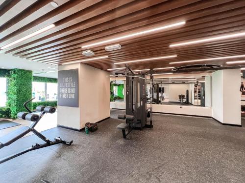 uma sala de fitness com um ginásio com uma passadeira e pesos em Elite Downtown Residences - Paradise View em Dubai
