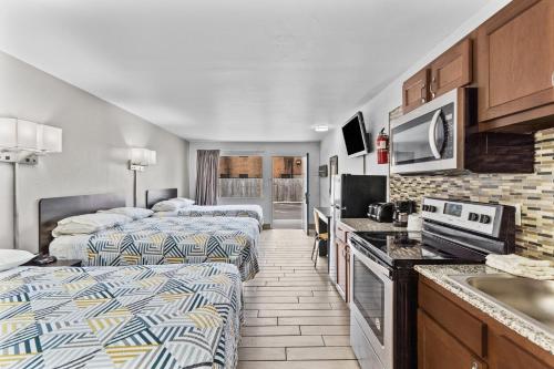 a hotel room with two beds and a kitchen at Studio 6 Wilmington, NC in Wilmington