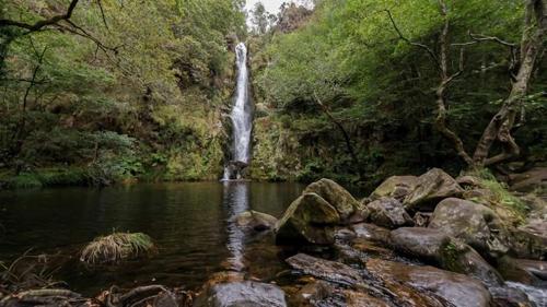 a waterfall in the middle of a river with rocks at Casa Pazos, Pedrafita do Cebreiro in Piedrafita