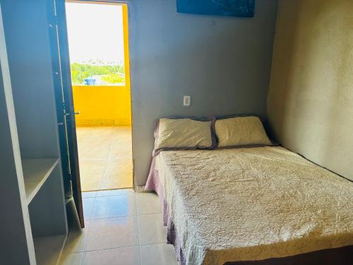 ein kleines Schlafzimmer mit einem Bett in einem Zimmer mit einem Fenster in der Unterkunft Vista Maravilhosa in Majorlândia