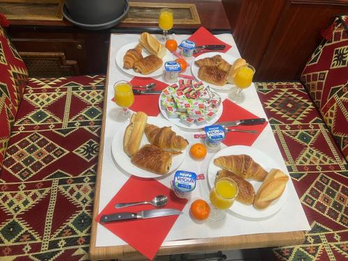 a table topped with plates of croissants and orange juice at Le Bon Moine in Reims