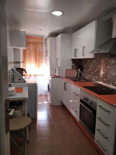 cocina con armarios blancos y fogones en Apartamento en La Manga, en La Manga del Mar Menor