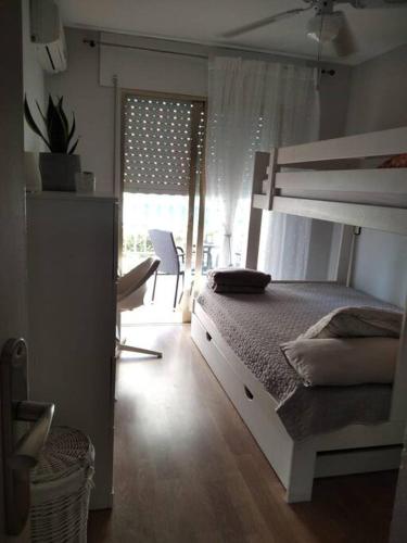 1 dormitorio con litera y ventana en Apartamento en La Manga, en La Manga del Mar Menor