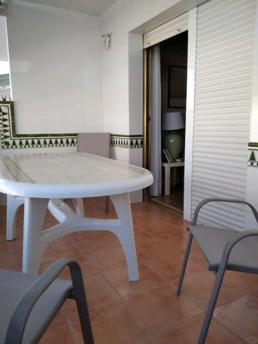una mesa blanca y sillas en una habitación en Apartamento en La Manga, en La Manga del Mar Menor