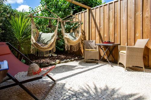 eine Terrasse mit 2 Hängematten und einem Zaun in der Unterkunft O'Jane de Boy in Lège-Cap-Ferret