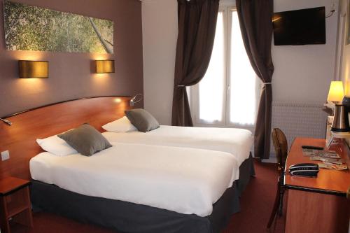 a hotel room with a large bed and a large window at Kyriad Hotel XIII Italie Gobelins in Paris