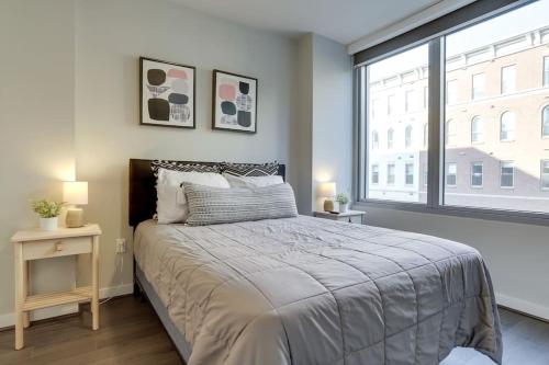a bedroom with a bed and a large window at Gorgeous 1 Bedroom At Clarendon With Gym and Rooftop in Arlington