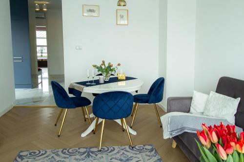 ein Wohnzimmer mit einem Tisch, Stühlen und einem Sofa in der Unterkunft Nowy Apartment przy Placu Szembeka in Warschau