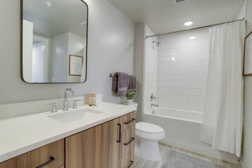 a bathroom with a sink and a toilet and a mirror at Gorgeous 1 Bedroom At Clarendon With Gym and Rooftop in Arlington