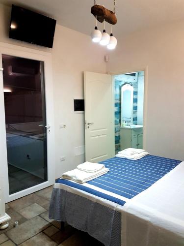 a bedroom with a bed with a blue striped sheet at Lu Salentu White House in Marina di Mancaversa