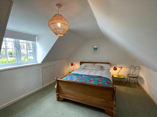 um quarto com uma cama e uma grande janela em Bodriggy Barn Holiday Cottage near St Ives em Hayle