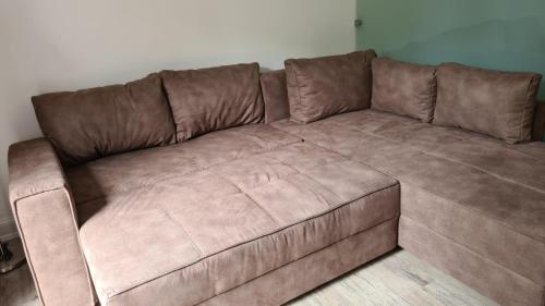 a brown leather couch in a living room at Ferienwohnung Baltrum auf dem Elisenhof Hagermarsch in Hagermarsch