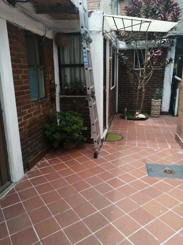a brick house with a ladder on a patio at Departamento Naval Coyoacán in Mexico City