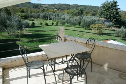 a table and chairs on a balcony with a view of a field at Casa Vacanze San Francesco in Bagni San Filippo
