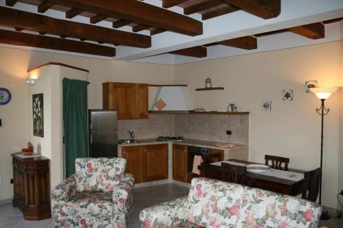 sala de estar con sofá y cocina en Casa Vacanze San Francesco en Bagni San Filippo