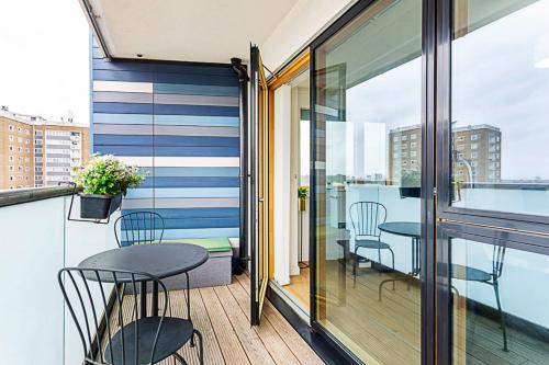 a balcony with a table and chairs on a building at Trendy Queen's Park Apartment with Views across London in London