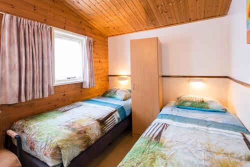 Duas camas num quarto com uma janela em Quisisana em Buren