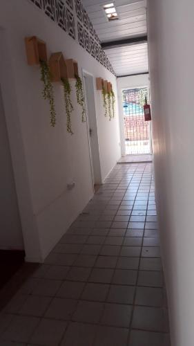a hallway with plants on the wall and a door at Pousada Bom Sucesso 59 in Olinda