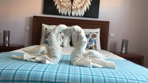 Una cama con toallas blancas encima. en ALOJAMENTO SAUDADE en Gafanha da Boa Hora