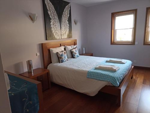 ein Schlafzimmer mit einem großen Bett mit zwei Kissen in der Unterkunft ALOJAMENTO SAUDADE in Gafanha da Boa Hora