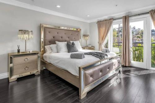 a bedroom with a large bed and a large window at Barham Boutique Townhouse in Los Angeles
