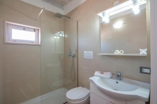 a bathroom with a shower and a toilet and a sink at Villa Barnaba Country House & Pool in Polignano a Mare