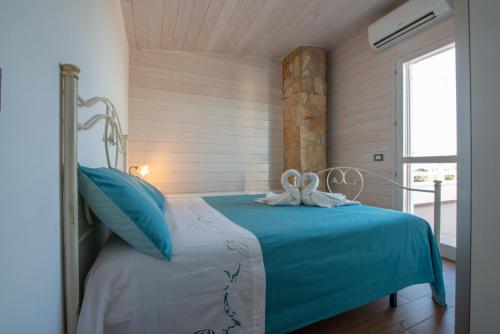 a bedroom with a bed with blue sheets and a window at Villa Barnaba Country House & Pool in Polignano a Mare
