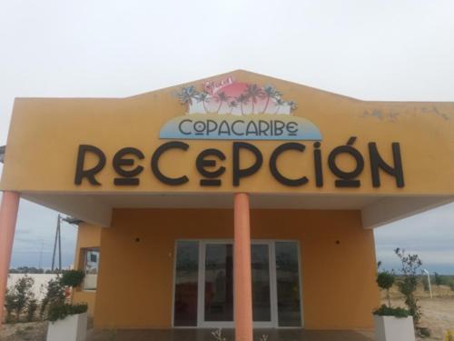 un panneau de restaurant au-dessus d'un bâtiment jaune dans l'établissement Hotel Copa Caribe, à San Antonio Oeste