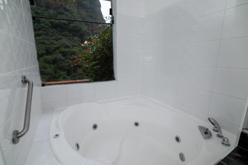a white bath tub in a bathroom with a window at Tierra Viva Machu Picchu Hotel in Machu Picchu