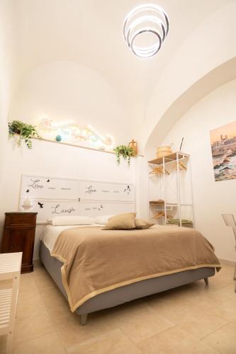 a bedroom with a bed in a white room at Le Stanze di Maria-Ingresso Autonomo Maria's Rooms-Indipendent Entrance in Giovinazzo