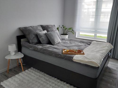 a bed with a tray of food on it at Apartament Happy Stay in Rzeszów