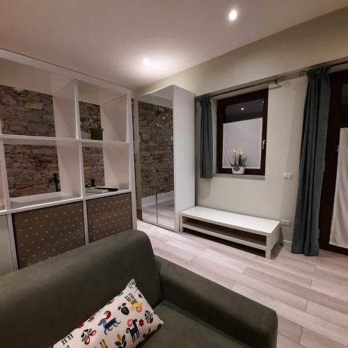 ein Wohnzimmer mit einem Sofa und einem Fenster in der Unterkunft Il Sole di Simona - Il Prato in Omegna