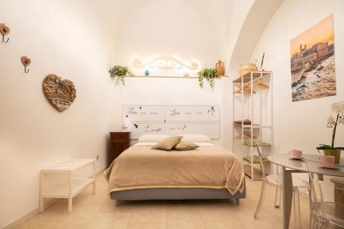 a white bedroom with a bed and a table at Le Stanze di Maria-Ingresso Autonomo Maria's Rooms-Indipendent Entrance in Giovinazzo