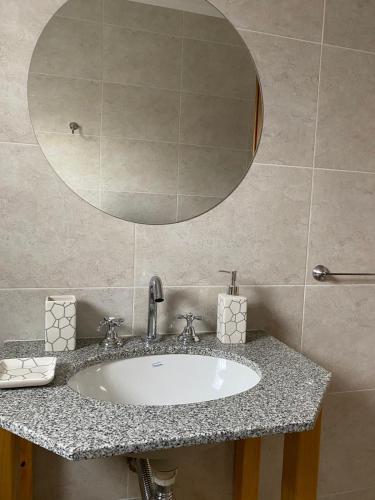 a bathroom with a sink and a mirror at Departamento los patitos in Lobos