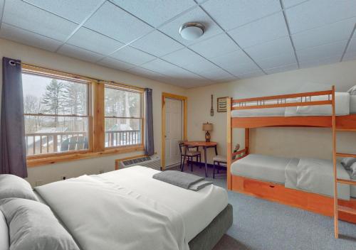 sypialnia z 2 łóżkami piętrowymi i biurkiem w obiekcie Lodge at Schroon Lake w mieście Schroon Lake
