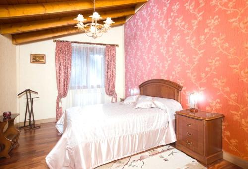 a bedroom with a bed and a pink wall at Chalet en Lesaka, cerca de San Sebastián in Lesaka