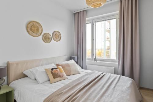 1 dormitorio con 1 cama con sábanas blancas y ventana en Amazing views by Finnoo metro, en Espoo