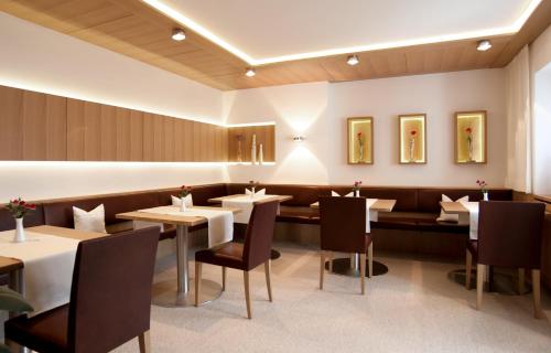 - un restaurant avec des tables et des chaises dans une salle dans l'établissement Haus Alpina, à Au im Bregenzerwald